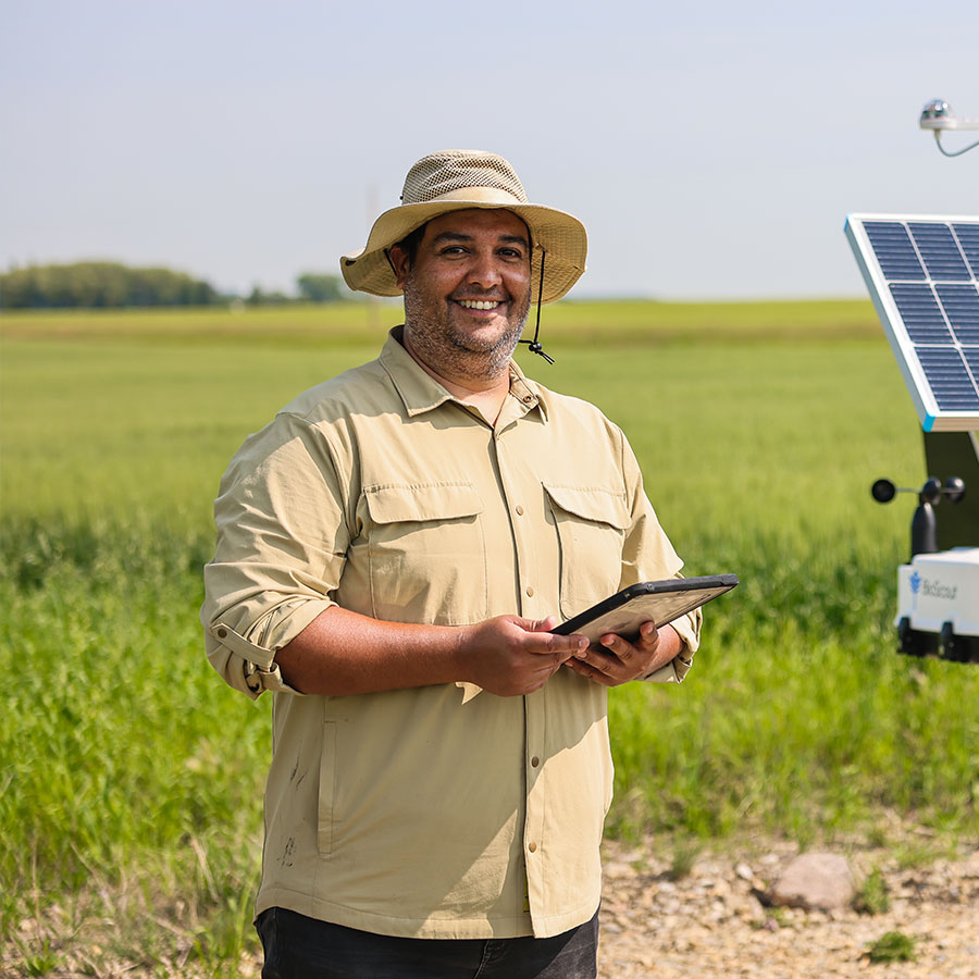 Juan Ramos standing on the Olds College smart farm in front of a sensor headshot